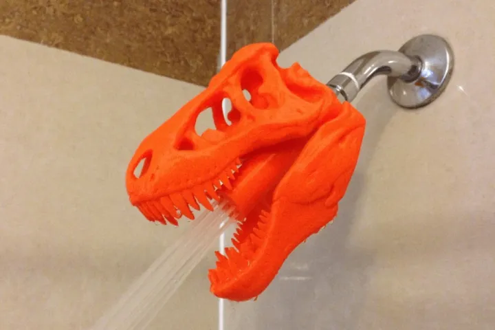 Cabezal de ducha con forma de cráneo de dinosaurio T-Rex impreso en 3D.